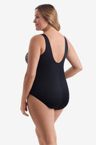 Woman turned left wearing a one-piece swimsuit with a multicolored dot pattern