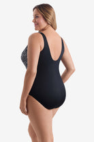 Woman turned left wearing a black and white paper mache printed one-piece swimsuit 