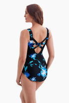 Woman turned left wearing a one-piece swimsuit with a blue floral pattern