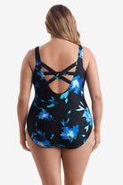 Woman turned away wearing a large blue floral printed one-piece swimsuit with an X back