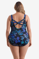 Woman turned away wearing a blue flower printed one-piece swimsuit with an X back