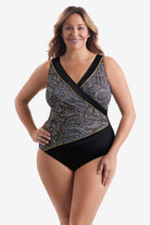 Woman wearing a black, white & gold dot pattern one-piece swimsuit