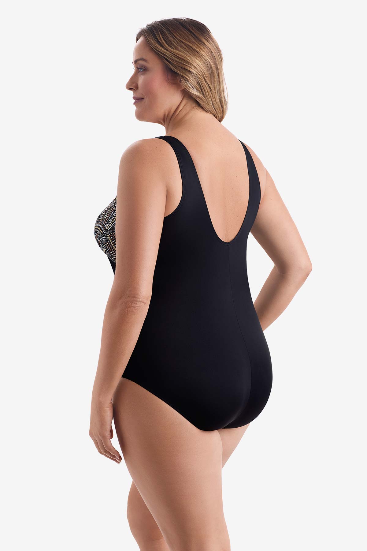 Woman turned left wearing a black, white & gold dot pattern one-piece swimsuit