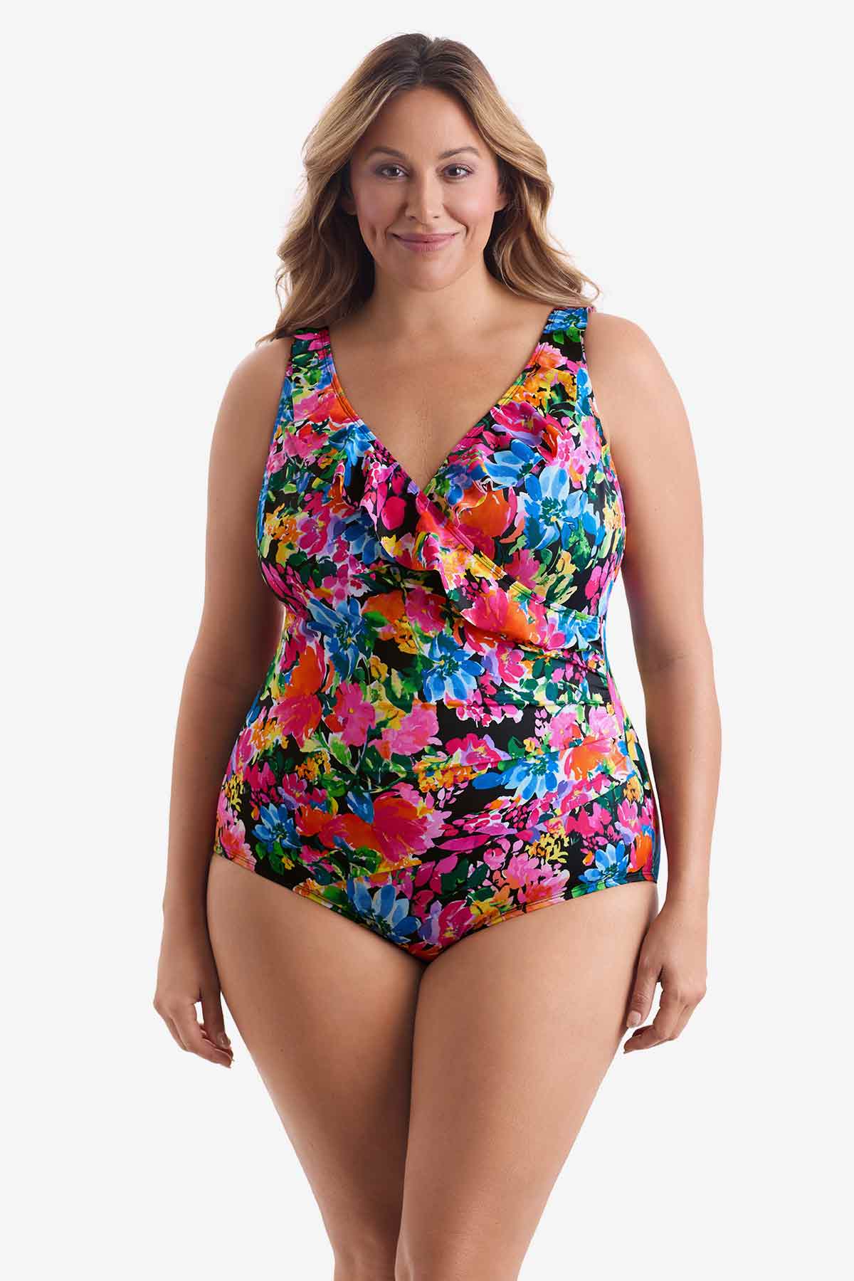 Woman wearing a multicolored floral one-piece swimsuit with ruffles on the neckline