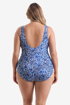 Woman faced away wearing blue and white fine china printed one-piece swimsuit