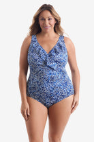 Woman wearing blue and white fine china printed one-piece swimsuit with ruffles on the neckline