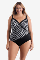 Woman wearing a black and white geometric pattern one-piece swimsuit