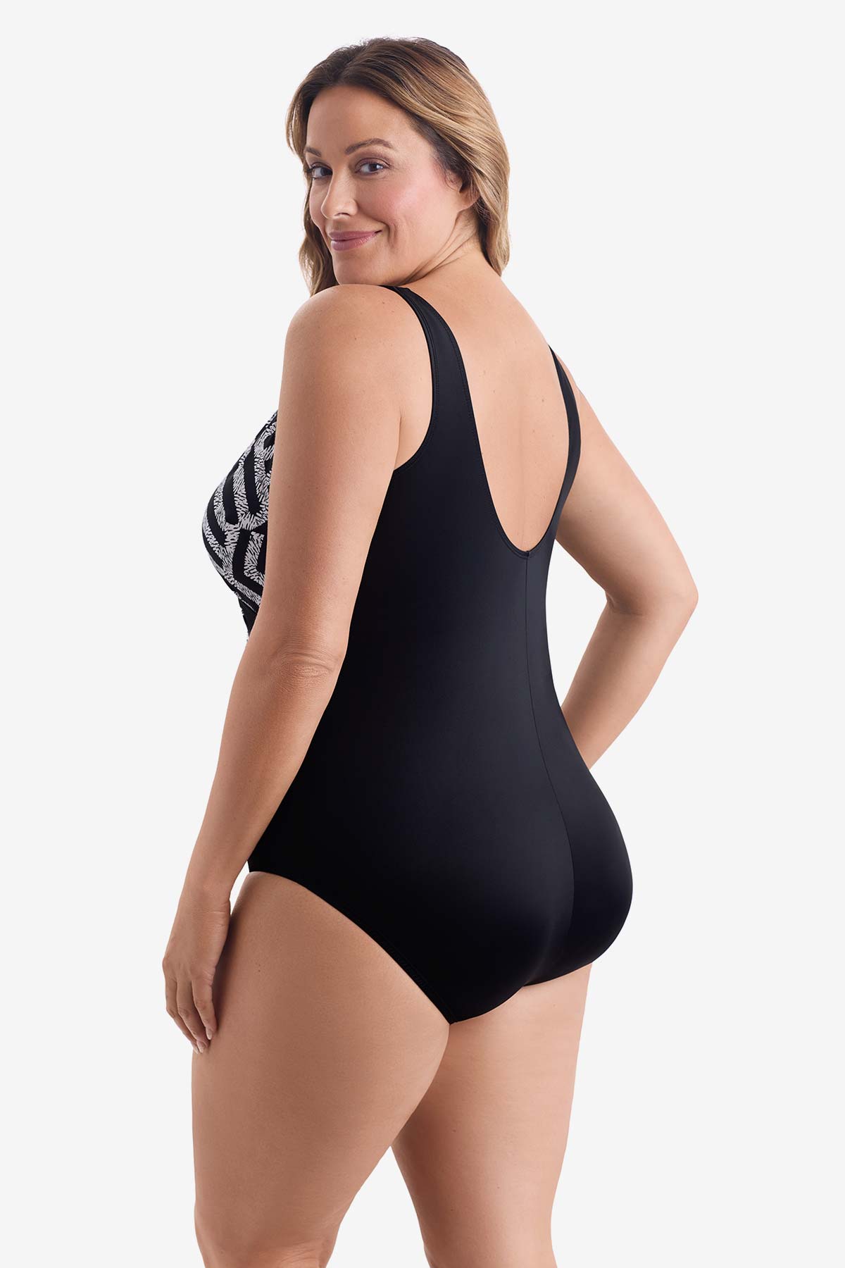 Woman turned left wearing a black and white geometric pattern one-piece swimsuit