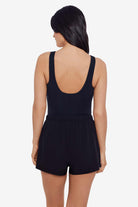 Woman faced away wearing a black one-piece romper swimsuit