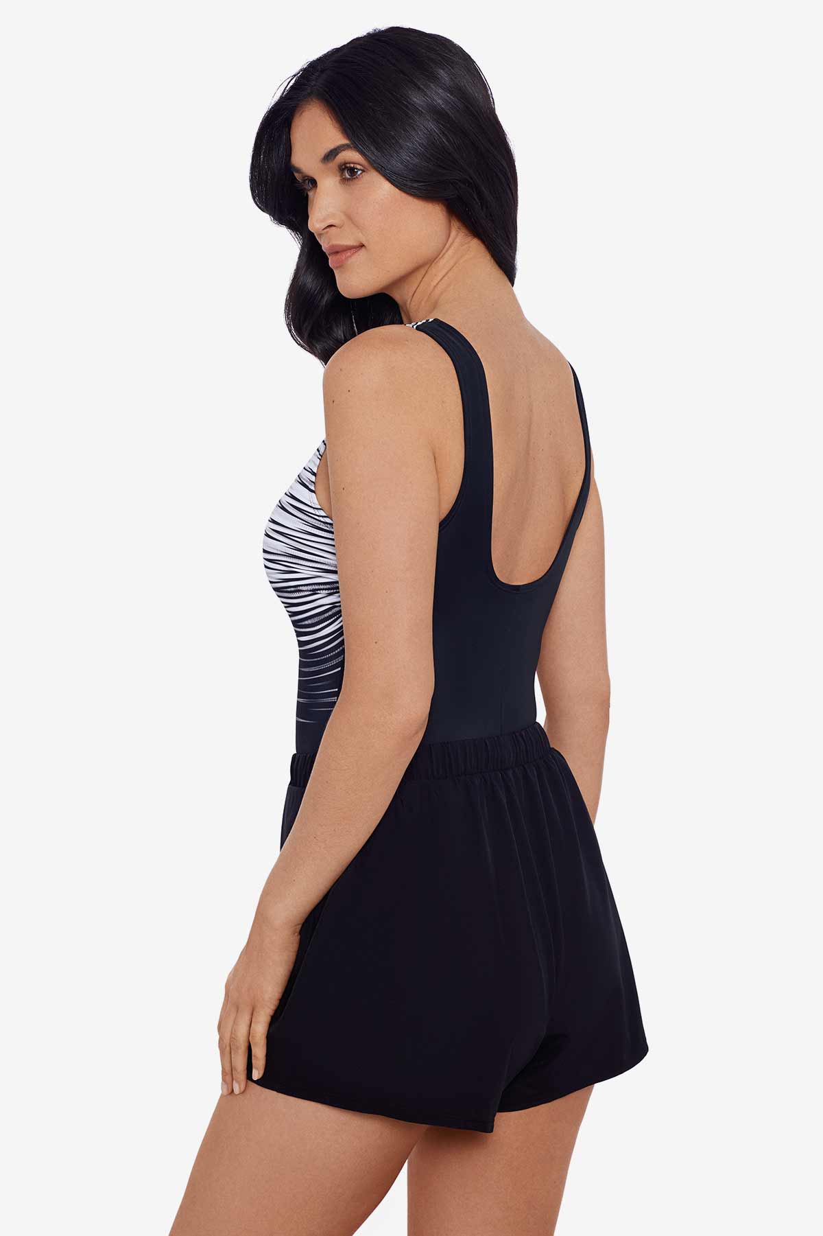 Woman faced left wearing a black and white stripey pattern one-piece romper swimsuit