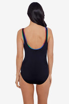 Woman faced away wearing a black one-piece swimsuit with rainbow piping on the straps