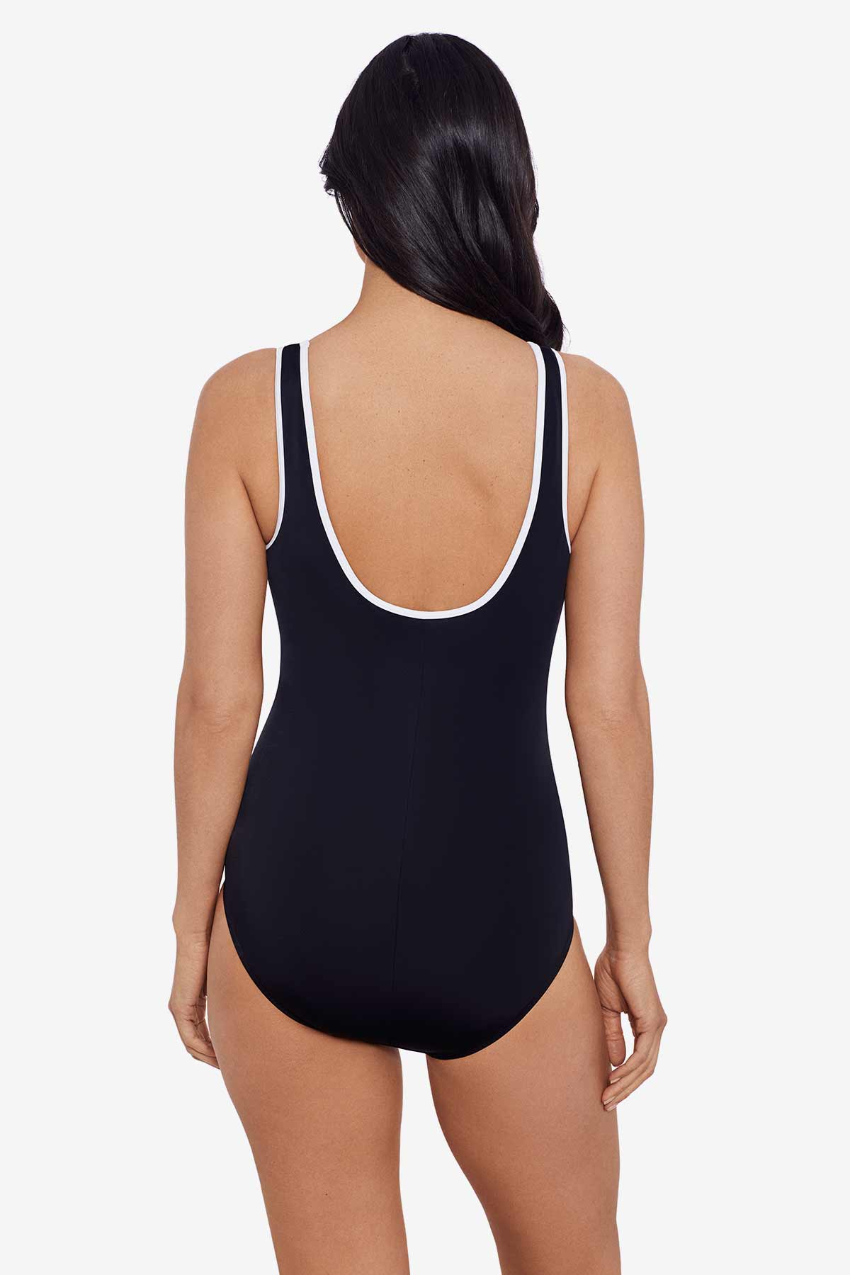 Woman faced away wearing a black one-piece swimsuit with white piping on the straps
