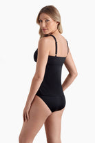 Woman faced left wearing a black one-piece swimsuit 