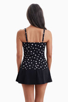 Woman faced away wearing a tankini top with black and white polka dots
