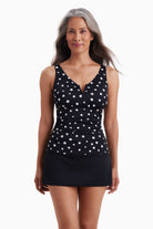 Woman wearing a tankini top with black and white polka dots
