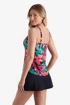 Woman faced left wearing a tankini top with a multicolored floral print