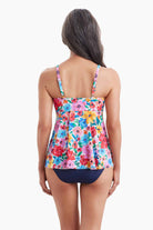 Woman turned away wearing a tankini top with a multicolored floral pattern