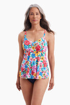Woman wearing a tankini top with a multicolored floral pattern