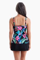 Woman faced away wearing a tankini top with a multicolored floral print
