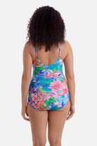 Woman turned away wearing a multicolored floral print sarong one-piece swimsuit