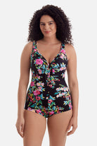 Woman wearing a multicolored floral printed one-piece swimsuit with ruffles on the neckline