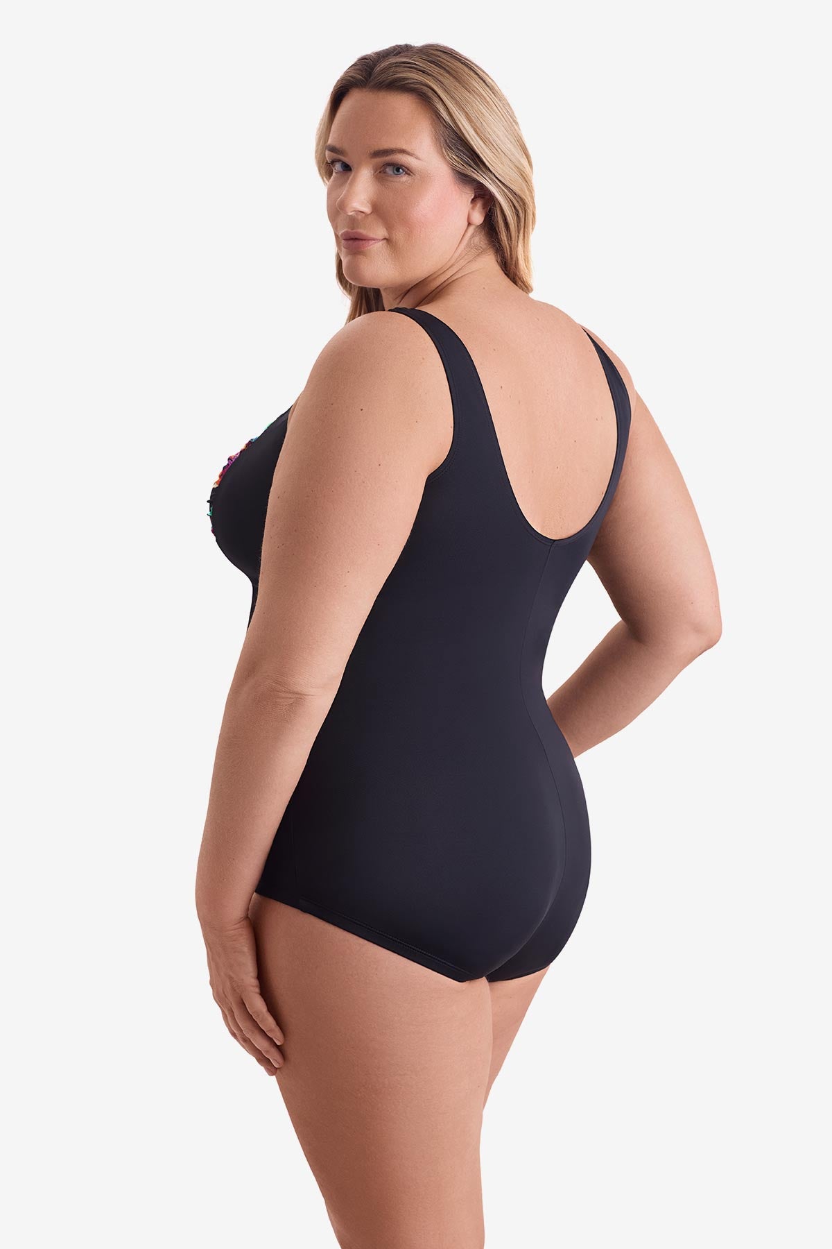 Woman turned left wearing a multicolored floral print down the middle of the one-piece swimsuit