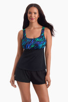 Woman wearing a tankini swim top with a multicolored print on the bust