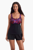 Woman wearing a tankini swim top with a pink pattern on the bust