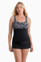 Woman wearing a tankini top with a black and white pattern across the bust