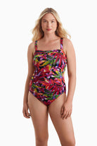 Woman wearing a multicolored one-piece swimsuit with a floral print