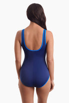 Woman turned away to show off blue trim on the one-piece swimsuit
