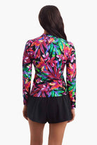 Woman faced away to show detail of the multicolored floral sun shirt