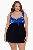 Woman wearing a black and blue swirled print at the bust of a black swim dress