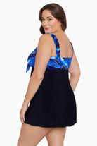 Woman faced left wearing a black and blue swirled print at the bust of a black swim dress