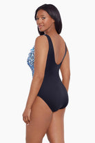 Woman turned left wearing a blue dotted print ruffle neck one-piece swimsuit