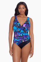 Woman wearing a blue and gold floral printed one-piece swimsuit