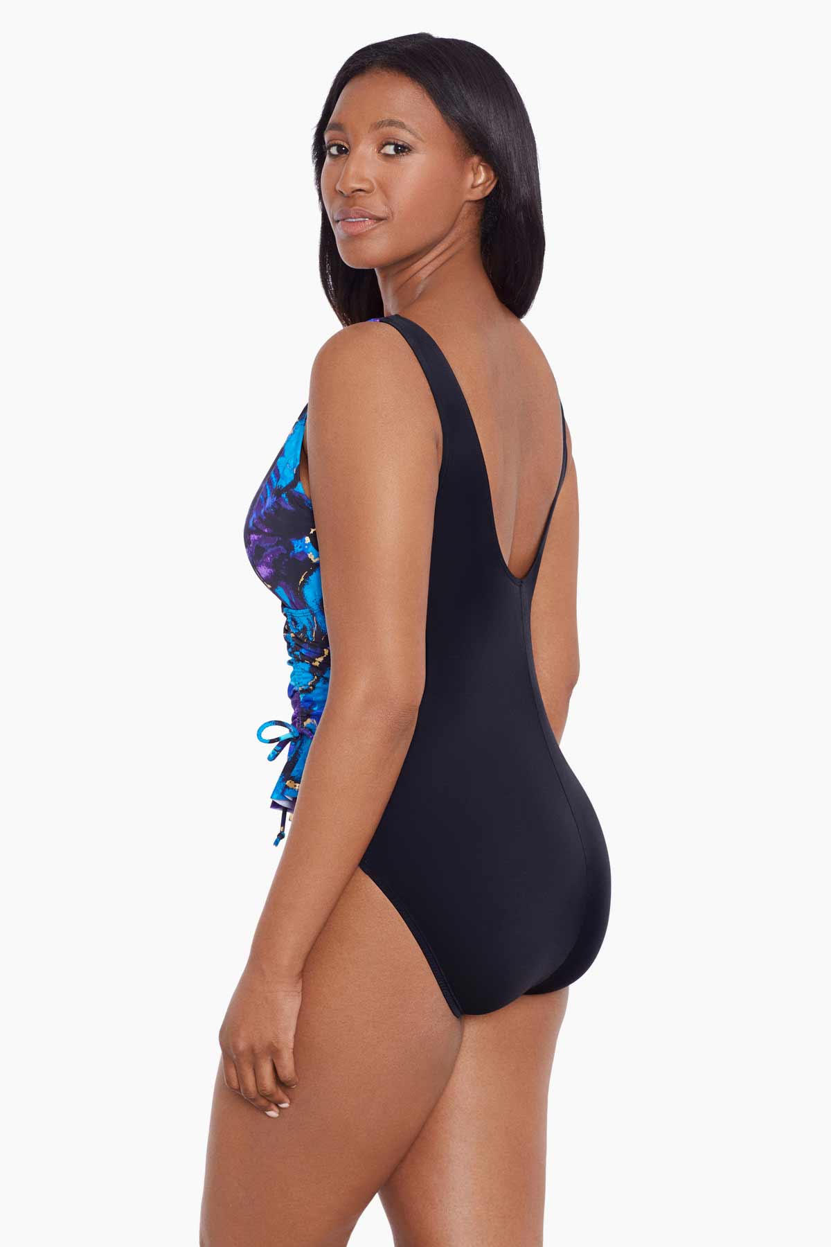 Woman turned left wearing a blue and gold floral printed one-piece swimsuit