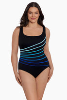 Woman wearing a black and blue ombre fan pattern one-piece swimsuit