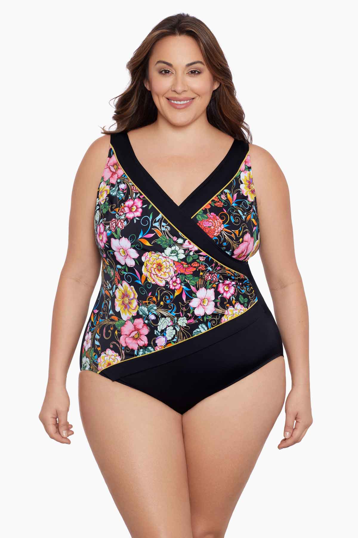 Woman wearing a floral printed one-piece swimsuit with black blocking