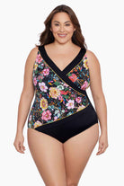 Woman wearing a floral printed one-piece swimsuit with black blocking