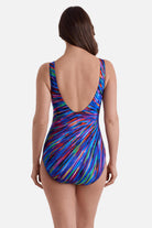 Woman turned away wearing a multicolor radial burst print one-piece swimsuit