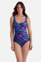 Woman wearing a multicolor radial burst print one-piece swimsuit