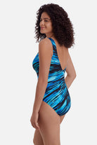 Woman turned left wearing a blue tie-dye one piece swimsuit