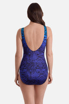 Woman turned away wearing an animal-esque printed one-piece swimsuit in blue