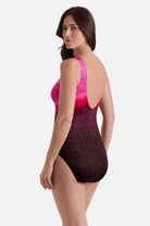 Woman turned left wearing a pink ombre one-piece swimsuit with shimmer detailing