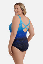 Woman faced left wearing a blue ombre one-piece swimsuit with shimmer detail