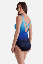 Woman wearing a blue ombre one-piece swimsuit with shimmer detail and X back