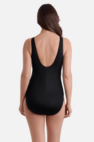 Woman turned away wearing a blue abstract printed one-piece swimsuit with black color blocking