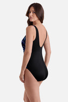 Woman turned left wearing a blue abstract printed one-piece swimsuit with black color blocking