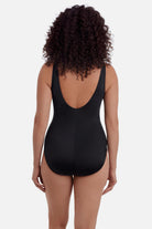 Woman turned away wearing a multicolor abstract printed one-piece swimsuit 